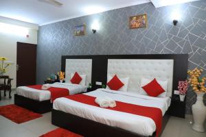 1 dormitorio con 2 camas y almohadas rojas y blancas en Hotel Global Inn By Quality Inn en Nueva Delhi