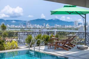 a balcony with a pool and a table and umbrella at Florence Hotel in Danang