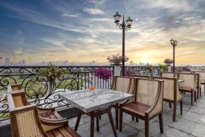 a patio with a table and chairs on a balcony at Florence Hotel in Da Nang
