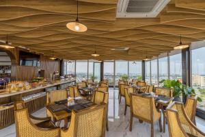 a restaurant with wooden ceilings and tables and chairs at Florence Hotel in Danang