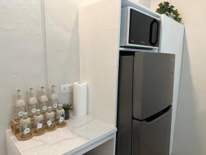 a kitchen with a refrigerator and a tv on a counter at Japandi Home B - Fully Aircon, WIFI, Hot shower, 24hGuard, Center, near Malls in General Santos