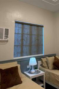 a room with a bed and a window with a lamp at Japandi Home B - Fully Aircon, WIFI, Hot shower, 24hGuard, Center, near Malls in General Santos