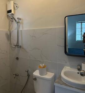 ein Badezimmer mit einem WC, einem Waschbecken und einem Spiegel in der Unterkunft Japandi Home B - Fully Aircon, WIFI, Hot shower, 24hGuard, Center, near Malls in General Santos