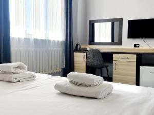 ein Hotelzimmer mit einem Bett mit Handtüchern darauf in der Unterkunft TourAsia Hotel in Bischkek