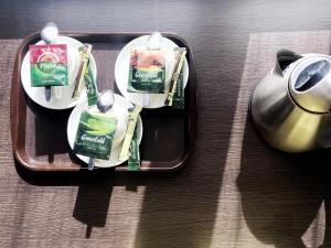 a tray with two plates of food and a tea pot at TourAsia Hotel in Bishkek