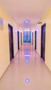 a long hallway with doors and a tile floor at Hotel Nawab's in Karīmnagar