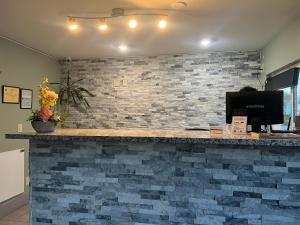 a lobby with a brick wall and a counter with a computer at University Inn Chico in Chico