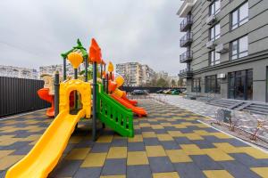 a playground with a yellow and orange slide at Стильные апартаменты,метро Вырлица,метро Харьковская in Kyiv