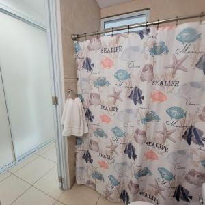 a bathroom with a shower curtain with fish and starfish at Dorado Beach Condo in Dorado