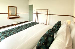 a large bed in a room with a mirror at Kanitri Villas Seminyak by MERE in Seminyak