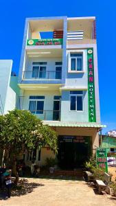 um edifício branco com um sinal em frente em Khách Sạn Chấn Phú Quý em Phú Quý