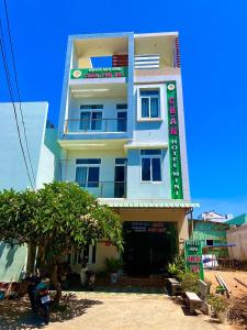 um edifício branco com um sinal em frente em Khách Sạn Chấn Phú Quý em Phú Quý