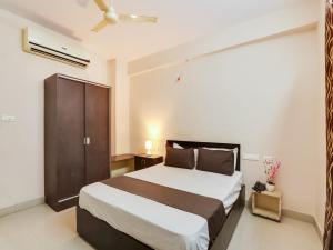 OYO Hotel Srinivasa Grand في حيدر أباد: غرفة نوم بسرير كبير في غرفة