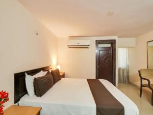um quarto de hotel com uma cama e uma cadeira em OYO Hotel Srinivasa Grand em Hyderabad
