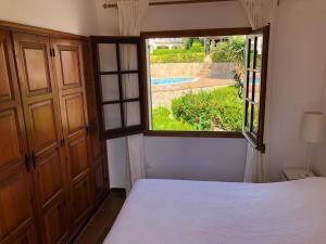 une chambre avec un lit et une grande fenêtre dans l'établissement Casa con Jardín, Piscina, y Terrazas en Zona Tranquila Cerca de L'Estartit - ES-323-24, à L'Estartit 18 autres photos