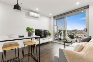 een woonkamer met een bank en een tafel bij Grandeur Apartment in Melbourne