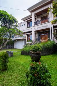 une maison avec une cour ornée de plantes et un bâtiment dans l'établissement Andaru Sukahaji - Perfect for Family and Friends, à Bandung