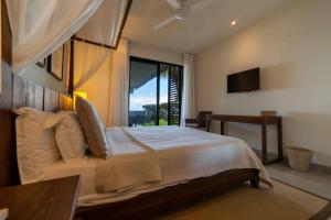 - une chambre avec un lit et une grande fenêtre dans l'établissement Beautiful 3 bed-room beachfront penthouse, à Grand Baie