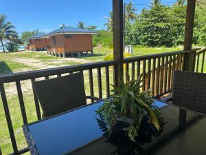 una mesa y sillas en un balcón con una casa en Parea Lodge Huahine BUNGALOW F2 #Miti, en Parea