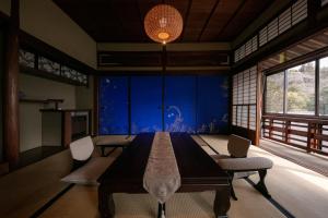 a dining room with a long table and chairs at Okamotoya in Beppu