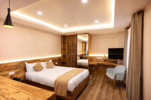Habitación de hotel con cama y TV en HOTEL BHRIKUTI TARA en Katmandú