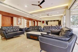 a living room with leather furniture and a ceiling fan at Kizhakkambalam Tourist Home in Muttam