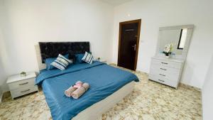 1 dormitorio con 1 cama azul y 2 zapatillas en Fresh Remodel Apt With New Ac en Amán
