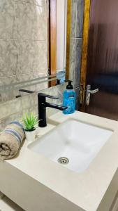 lavabo con grifo negro en Fresh Remodel Apt With New Ac, en Amán