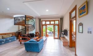 a living room with a blue couch and a blue chair at Andaru Sukahaji - Perfect for Family and Friends in Bandung