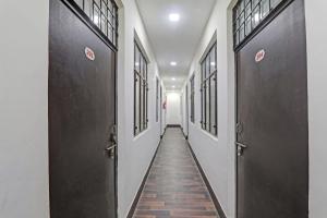 un corridoio con 2 porte nere e pavimento piastrellato di OYO Flagship Hotel New Pacifica Grand Near Phoenix United Lucknow a Charbagh