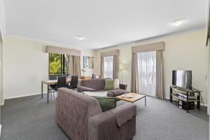 ein Wohnzimmer mit einem Sofa und einem Tisch in der Unterkunft Northbridge Prime Location*2BR in Perth