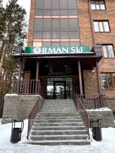 an entrance to a building with stairs in the snow at Orman Ski in Shchuchinskiy