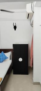 - une chambre avec une armoire noire à côté d'un lit dans l'établissement 1BR Apartment in Lower Parel, à Mumbai