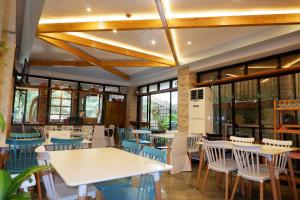 restauracja ze stołami, krzesłami i oknami w obiekcie Casi Verde Arc Homes w Panglao City