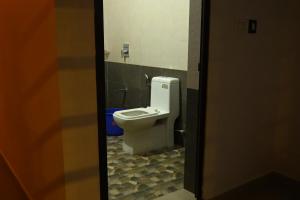 a bathroom with a white toilet in a stall at Cloudy Cove Resort in Meppādi
