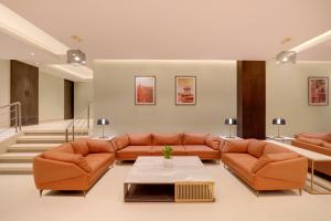 a living room with orange leather couches and a table at Keys Select by Lemon Tree Hotels, Udaipur in Udaipur