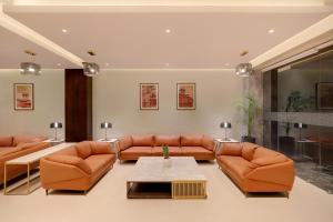 a living room with orange leather couches and a table at Keys Select by Lemon Tree Hotels, Udaipur in Udaipur