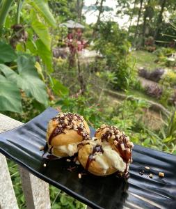 dos donuts sentados en la parte superior de un banco en Air Manis Hillside Villa Cafe & Resto, en Padang