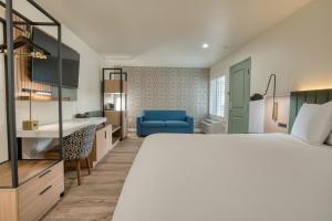 a hotel room with a large bed and a blue chair at La Casa Inn in San Francisco