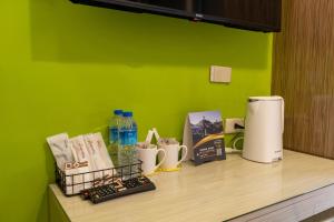 a kitchen counter with a green wall and a counter top with coffee makers at Guide Hotel Taipei Dadaocheng in Taipei