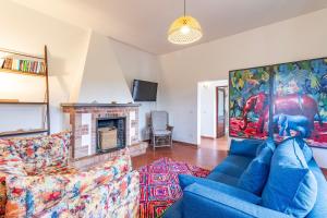 sala de estar con sofá azul y chimenea en La Casa Della Quercia Relax In Tuscany - Happy Rentals, en Montaione