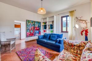sala de estar con sofá azul y alfombra en La Casa Della Quercia Relax In Tuscany - Happy Rentals, en Montaione
