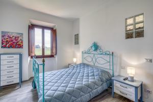 Un dormitorio con una cama azul y una ventana. en La Casa Della Quercia Relax In Tuscany - Happy Rentals, en Montaione
