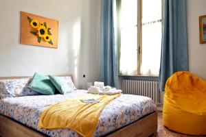 a bedroom with a bed with a yellow blanket and a window at Casa Del Teatro in Pavia