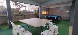 d'une terrasse avec une table de ping-pong et des chaises blanches. dans l'établissement กิติ์ชาวิว วิลล่า, à Ban Nang Lae