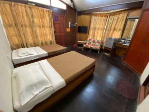 Habitación pequeña con 2 camas y escritorio. en PCB BEACH RESORT en Kota Bharu