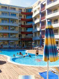 una piscina con ombrellone e persone in un hotel di Central Plaza Studio a Sunny Beach