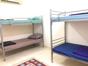two bunk beds in a room with a rug at Heritage Hostel Muscat in Muscat