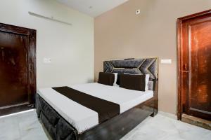 um quarto com uma cama branca e preta em OYO The Happy Homestay em Moradabad