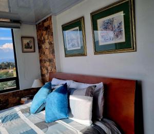 una camera da letto con un letto con cuscini blu e bianchi di Comfort Club a Guatavita